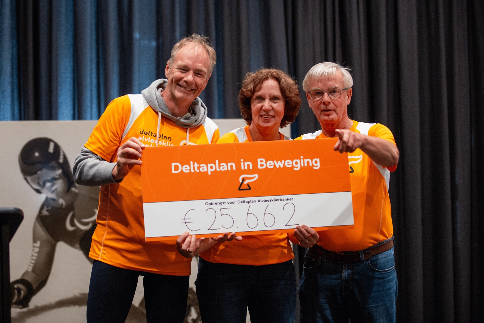 Drie deelnemers tonen de cheque van Deltaplan in Beweging