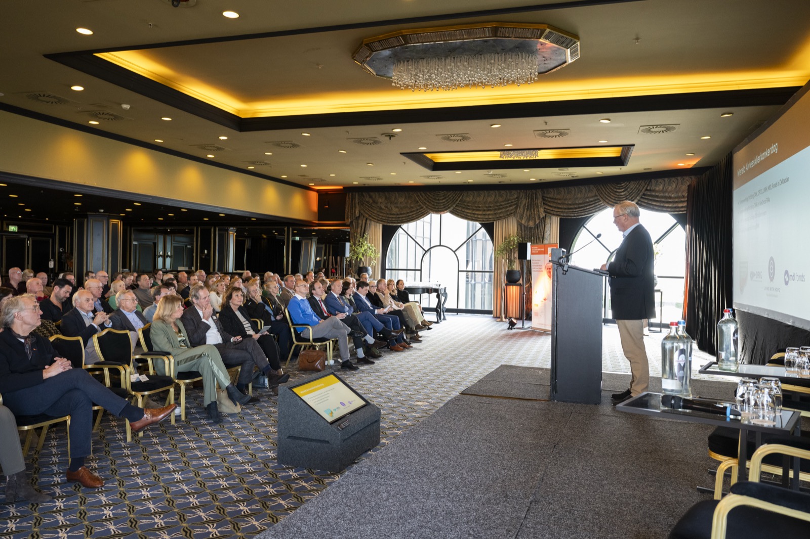 Spreker en bezoekers tijdens het symposium in Grand Hotel Huis ter Duin